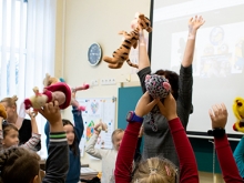 Children lifting their toys in the air during an active school activity at Sendvaris Progymnasium in Klaipeda
