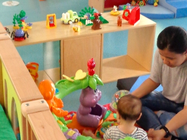 Mother playing with her infant child at the Paris Toy Library during a Playful Paradigm Study Visit