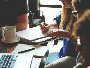 People sat around a table at a meeting