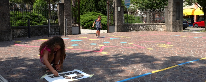 Children drawing they're own games on a city's pavement